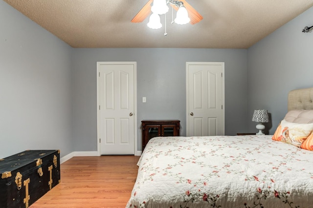 bedroom with ceiling fan, a textured ceiling, and light hardwood / wood-style flooring