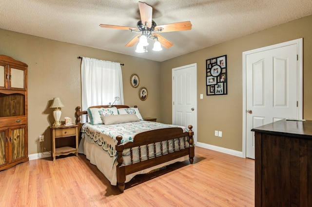 bedroom with ceiling fan, a textured ceiling, and light wood-type flooring