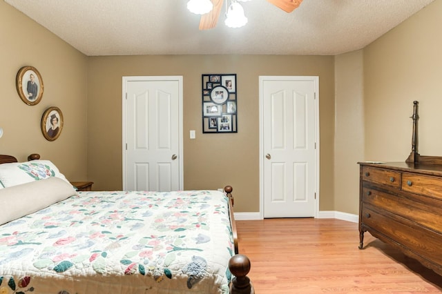 bedroom with a textured ceiling, ceiling fan, and light wood-type flooring