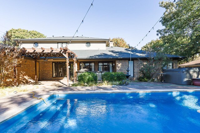 back of property featuring a hot tub, a pergola, and a patio area