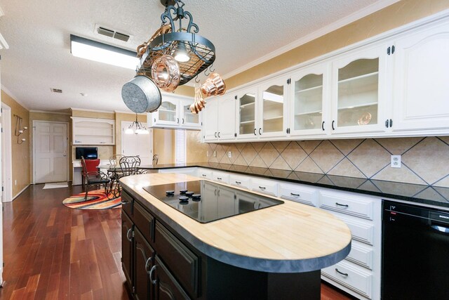 kitchen featuring pendant lighting, white cabinets, a center island, and black appliances