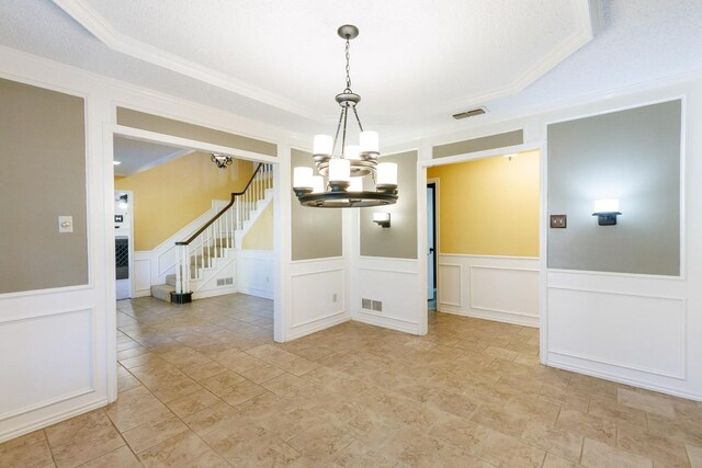 unfurnished dining area featuring crown molding, a textured ceiling, and an inviting chandelier