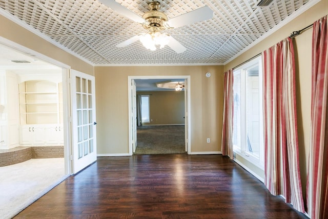 unfurnished room with crown molding, built in features, dark hardwood / wood-style floors, and ceiling fan