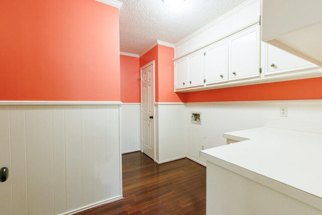 washroom featuring crown molding, dark wood-type flooring, hookup for a washing machine, cabinets, and a textured ceiling