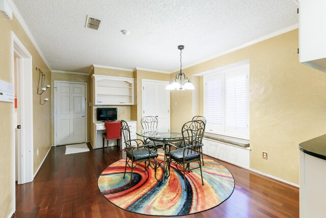 dining room featuring dark hardwood / wood-style flooring, a notable chandelier, ornamental molding, and a textured ceiling