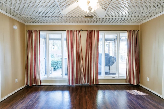 spare room with crown molding, dark wood-type flooring, and ceiling fan