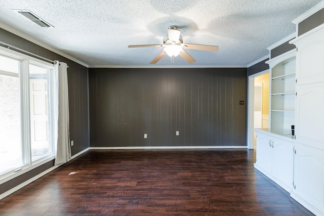 unfurnished room with crown molding, dark wood-type flooring, a textured ceiling, and ceiling fan