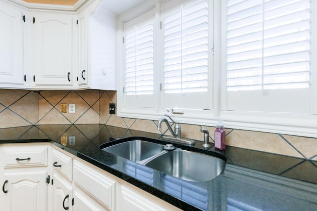 kitchen with backsplash, a wealth of natural light, sink, and white cabinets