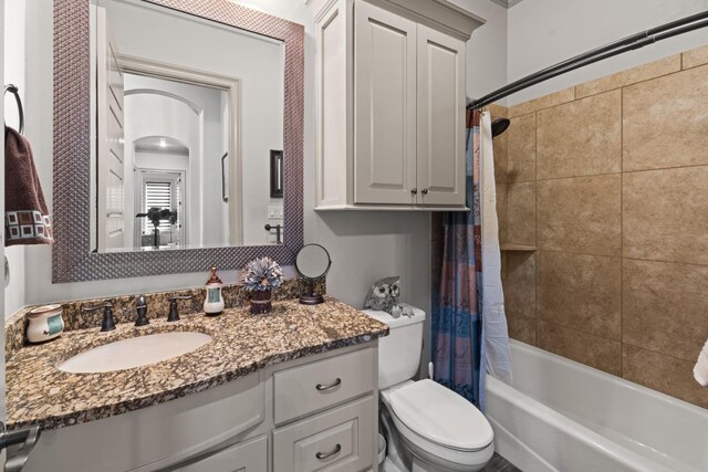 full bathroom with vanity, shower / bath combination with curtain, and toilet