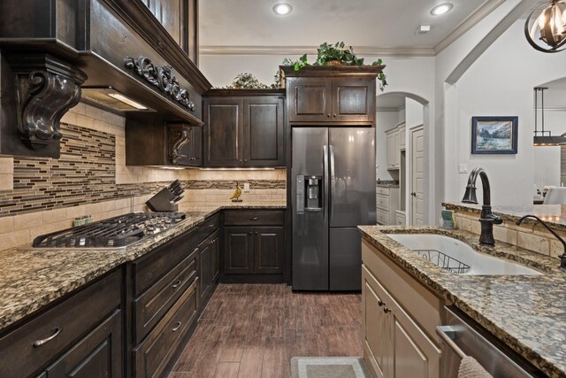 kitchen featuring stainless steel appliances, light stone countertops, and sink