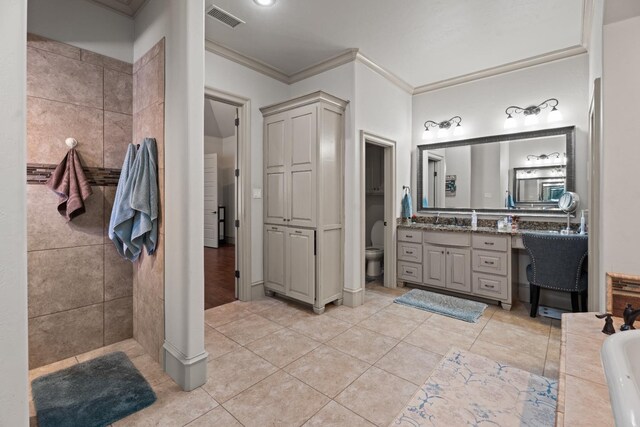 bathroom featuring tile walls, tile patterned flooring, vanity, toilet, and crown molding