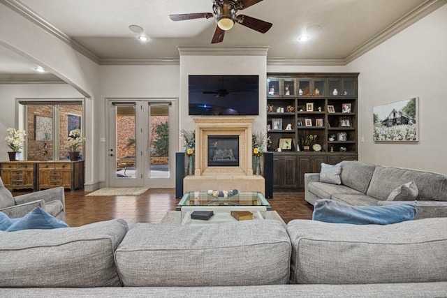 living room with dark hardwood / wood-style flooring, ornamental molding, and ceiling fan