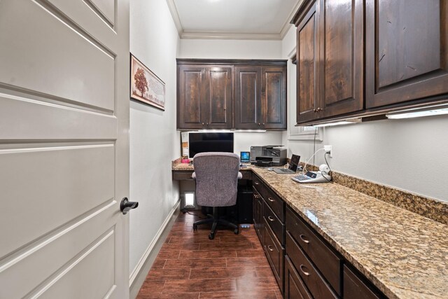 home office with ornamental molding, built in desk, and dark hardwood / wood-style flooring