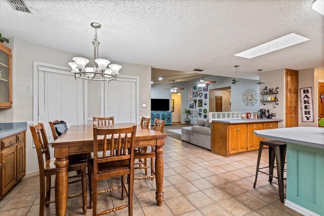2917 Dove Ln, Denver City, TX 79323 - dining room featuring a chandelier, a textured ceiling, light tile patterned floors, a skylight, and ceiling fan