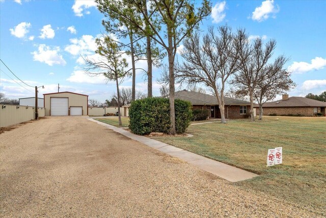 2917 Dove Ln, Denver City, TX 79323 - view of front of house with driveway, a detached garage, a front lawn, and an outdoor structure