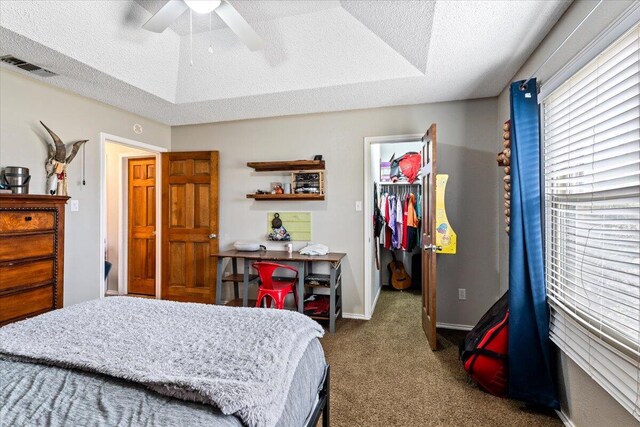 2917 Dove Ln, Denver City, TX 79323 - bedroom with a walk in closet, a textured ceiling, carpet, a closet, and ceiling fan