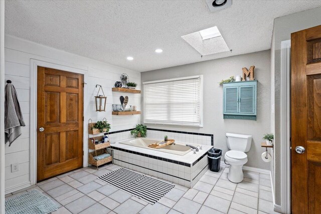 2917 Dove Ln, Denver City, TX 79323 - full bathroom with a skylight, a garden tub, toilet, a textured ceiling, and tile patterned flooring