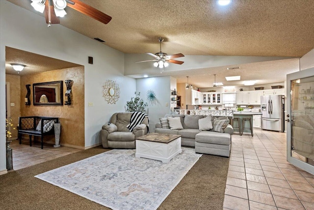 2917 Dove Ln, Denver City, TX 79323 - living room with lofted ceiling, a ceiling fan, light colored carpet, a textured ceiling, and light tile patterned flooring