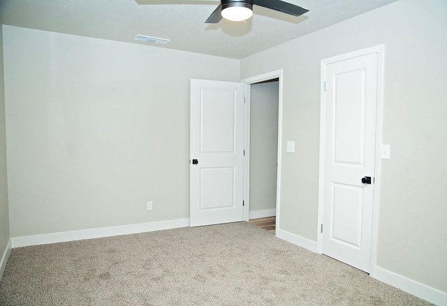 unfurnished bedroom with ceiling fan and carpet