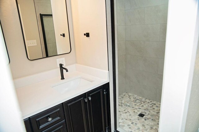 bathroom featuring vanity and tiled shower