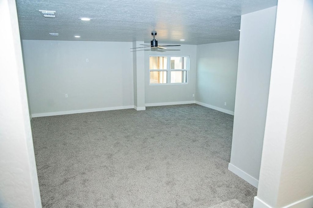 carpeted spare room with ceiling fan and a textured ceiling