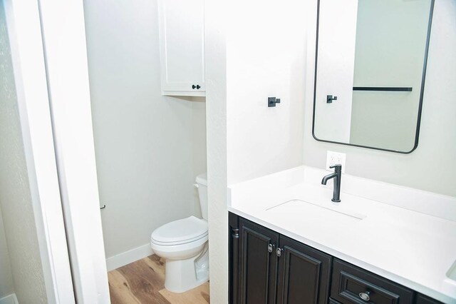 bathroom featuring vanity, toilet, and hardwood / wood-style floors