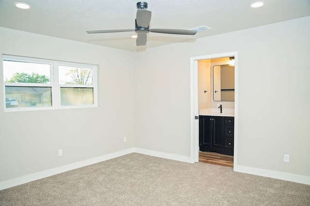 unfurnished bedroom with ensuite bath and light carpet