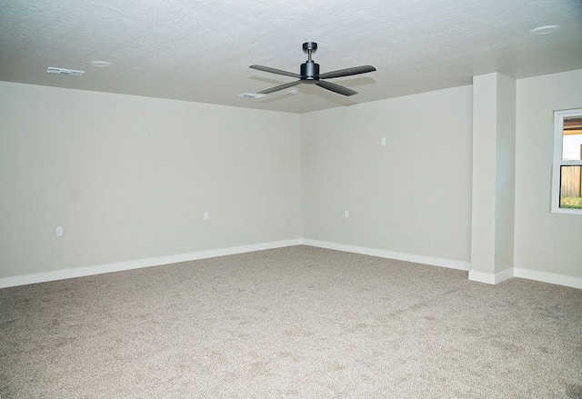 spare room featuring ceiling fan, a textured ceiling, and carpet flooring