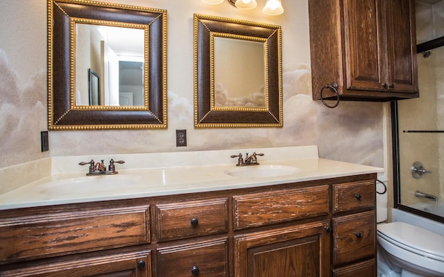 full bathroom with enclosed tub / shower combo, vanity, and toilet