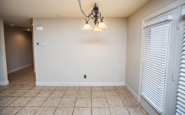 unfurnished dining area featuring an inviting chandelier