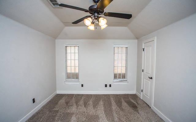 carpeted spare room featuring vaulted ceiling and ceiling fan