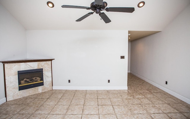 unfurnished living room featuring ceiling fan, a tiled fireplace, and vaulted ceiling