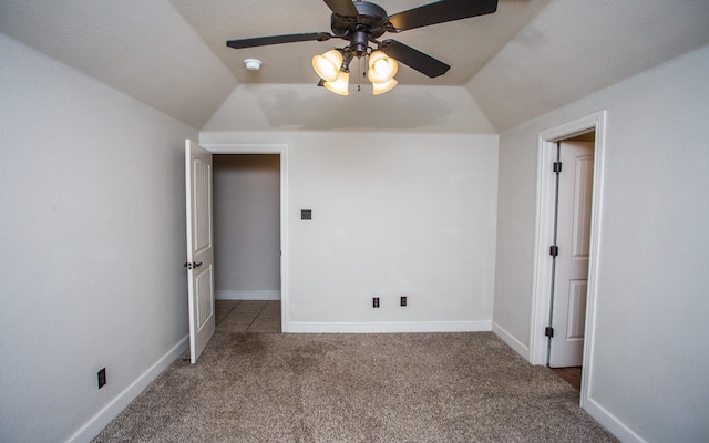 interior space featuring ceiling fan, carpet floors, and vaulted ceiling