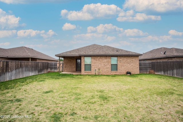7314 29th St, Lubbock, TX 79407 - back of house with a fenced backyard, brick siding, and roof with shingles