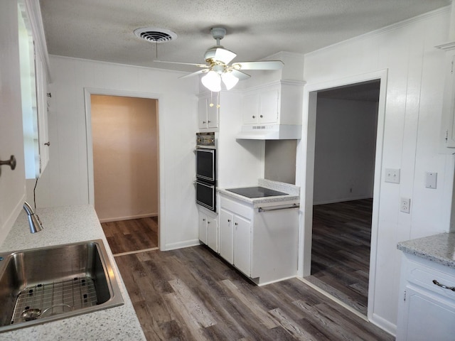 kitchen featuring black electric cooktop, dark hardwood / wood-style floors, sink, and white cabinets