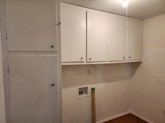 laundry room featuring hookup for a washing machine, dark hardwood / wood-style floors, cabinets, and a textured ceiling