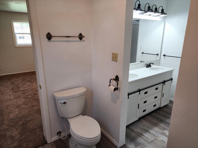 bathroom with hardwood / wood-style flooring, vanity, and toilet