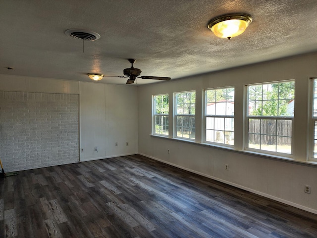 unfurnished room featuring ceiling fan, dark hardwood / wood-style floors, and a textured ceiling