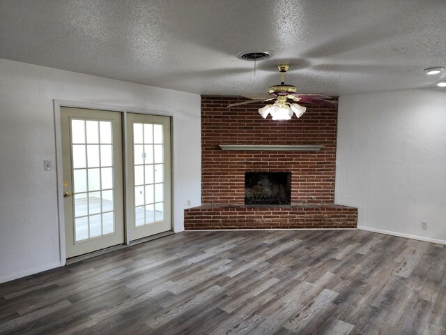 unfurnished living room with ceiling fan, a textured ceiling, a fireplace, and wood-type flooring