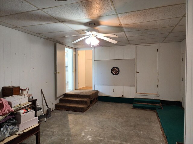 basement featuring ceiling fan and a paneled ceiling