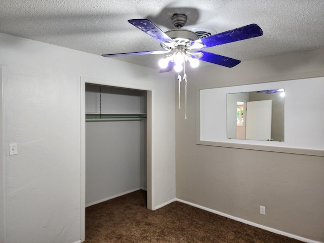 unfurnished bedroom featuring ceiling fan, dark carpet, a closet, and a textured ceiling