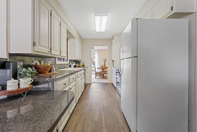 7007 Miami Ave, Lubbock, TX 79413 - kitchen featuring freestanding refrigerator, dark wood-style flooring, dishwasher, stainless steel gas range, and a textured ceiling