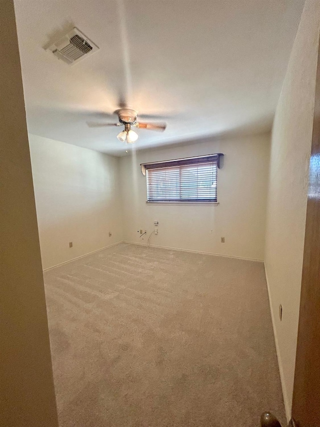 unfurnished room with ceiling fan and carpet