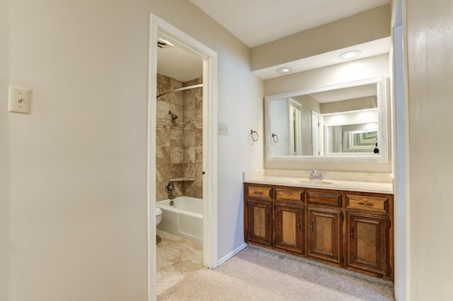 full bathroom featuring tiled shower / bath combo, vanity, and toilet