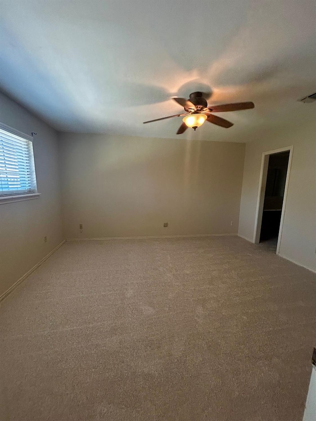 unfurnished room featuring ceiling fan and carpet