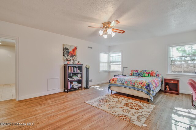1901 31st St, Lubbock, TX 79411 - bedroom featuring wood finished floors, a textured ceiling, baseboards, and a ceiling fan