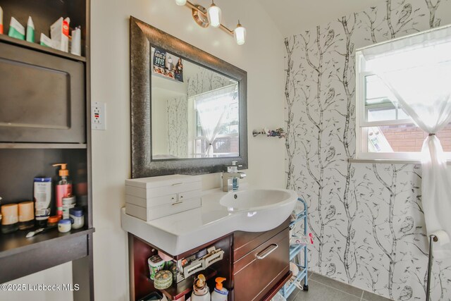 1901 31st St, Lubbock, TX 79411 - bathroom featuring wallpapered walls, vanity, lofted ceiling, and tile patterned flooring