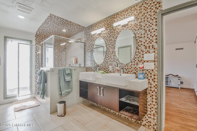 1901 31st St, Lubbock, TX 79411 - bathroom featuring double vanity, plenty of natural light, a tile shower, and backsplash