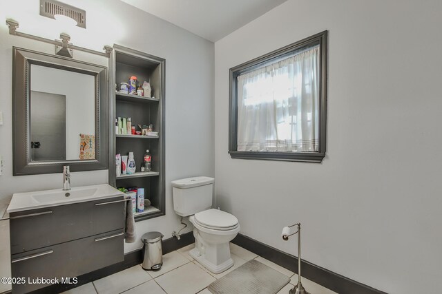 1901 31st St, Lubbock, TX 79411 - bathroom featuring vanity, toilet, tile patterned flooring, and baseboards