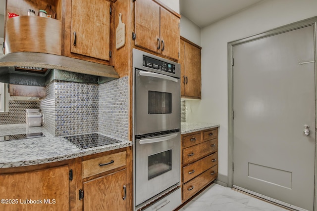 1901 31st St, Lubbock, TX 79411 - kitchen with stainless steel double oven, black electric cooktop, decorative backsplash, light marble finish flooring, and brown cabinets